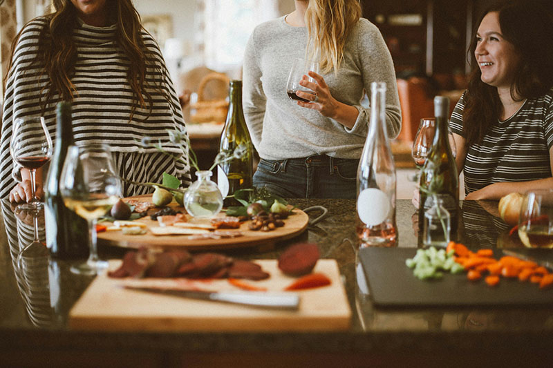 Women standing up talking at a dinner party